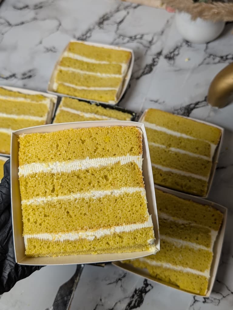 Lemon cake slice with cream layers in a white box