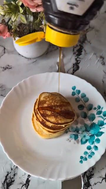Syrup being poured over Estee’s fluffy pancakes